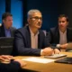 Business meeting of tech executives discussing AI transformation in 2025, featuring laptops and a modern conference room, representing the leadership of Microsoft, Google, and Amazon in cloud and AI, amidst challenges faced by Apple and hardware companies due to global trade impacts.