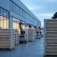 A futuristic warehouse landscape featuring advanced robotic arms automating the handling of stacked crates, showcasing AI integration in modern logistics.