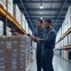 Modern warehouse workers efficiently scanning inventory with barcode scanners in a well-organized storage facility, showcasing advanced technology and real-time data tracking.