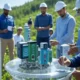 A group of workers in blue uniforms and hard hats inspecting advanced technology devices, including IoT sensors and RFID tags, outdoors in a lush green landscape, highlighting supply chain transparency and modern innovations by companies like Patagonia, Unilever, and Walmart.