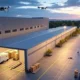 AI-driven logistics in across the US featuring autonomous delivery vehicles and drones optimizing routes in a modern urban setting.