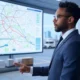 A logistics manager in a suit analyzing AI-powered route optimization on a large digital map display, with trucks in the background, highlighting fuel efficiency and smart delivery planning in a modern warehouse.
