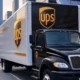A futuristic UPS delivery truck optimized with AI technology for route optimization and warehouse automation, parked in a modern urban setting with robotic warehouse systems in the background, showcasing sustainable logistics practices.