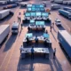 A group of logistics workers collaborating with digital tablets in a modern supply chain hub, surrounded by warehouses and trucks, showcasing AI-driven optimization and efficient operations in the United States.