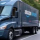 Amazon AI-powered delivery trucks optimizing routes across diverse U.S. terrains, including cities, suburbs, and rural areas, showcasing efficient logistics with real-time data processing and innovative technology.