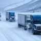 A snowy Colorado highway with multiple trucks navigating through a sudden snow burst, showcasing AI hazard prediction technology in action to ensure safe and timely logistics deliveries.
